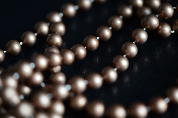 Long necklace of brown beads on a dark background close up