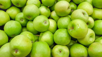 background of many ripe and delicious green apples close-up