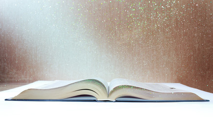 light from a magical book with reflections and green lights against an old and shabby wall