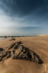 Fototapeta na wymiar Girl walks on the beach in Atlantic coast near Essaouira, Morocco.