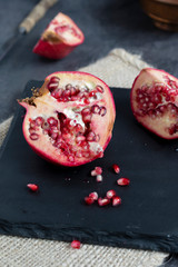 pieces of pomegranate on slate tray. Dark and moody light concept. 