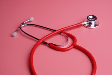 Stethoscope on pink background.