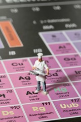 cuoco in miniatura sulla tavola periodica degli elementi chimici