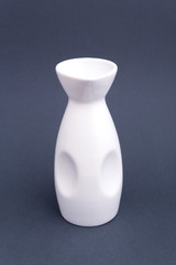 Ceramic white bottle for sake on grey background. Mock up for design.