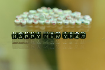 HAPPY NEW YEAR 2019 written with Acrylic Black cube with white Alphabet Beads on the Glass Background