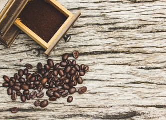 Coffee beans and grinders on old wooden boards.
