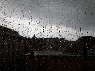 An amazing photography of some waterdrops over the window after summer rain in the city