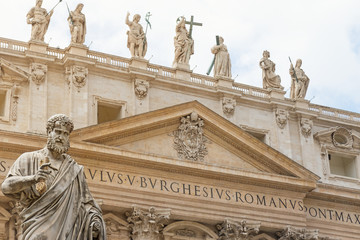Closeup view of the St. Peter Statue. St. Peter's Basilica is in the background.