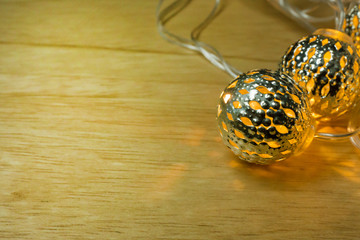 Christmas gold lights ball decor on wood table.