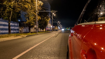Driving from side of car moving on a night avenue in city