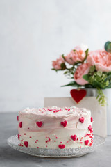 Close Up of a cake decorated with small hearts against a gray background. Romantic love concept. Valentine's, Mother's Day, Birthday Cake card Background.
