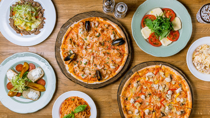 Fototapeta na wymiar Italian pizzas and salads top view