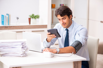 Fototapeta premium Man under stress measuring his blood pressure