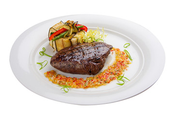Veal steak with salsa on a white plate
