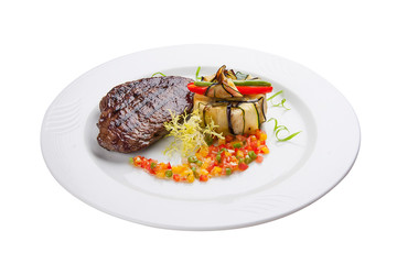 Veal steak with salsa on a white plate