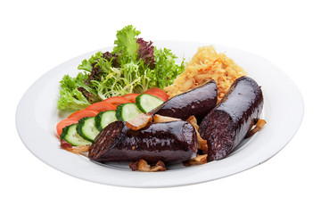 Blood sausage with vegetables and salad. On a white plate