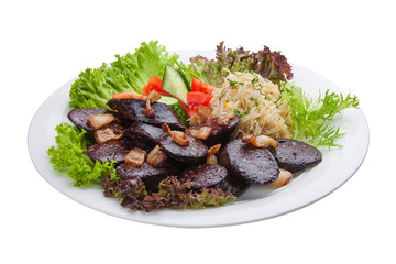 Blood sausage with vegetables and salad. On a white plate