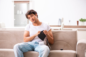 Obraz premium Young man measuring blood pressure at home