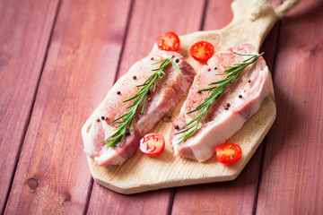 Fresh raw pork on the cutting board with ingredients for cooking. Food, flat lay, recipes and nutrition concept. Top view. Close up.