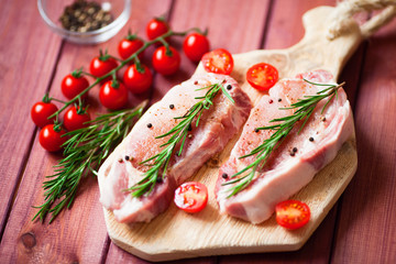 Fresh raw pork on the cutting board with ingredients for cooking. Food, flat lay, recipes and nutrition concept. Top view. Close up.