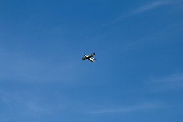 the plane is flying in the blue sky