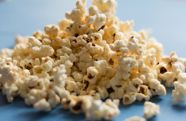 a bunch of popcorn on a blue background, selective focus