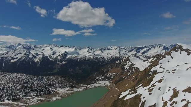 Aerial view on Ritom lake between snow-capped mountains at spring, Switzerland alps, 4k