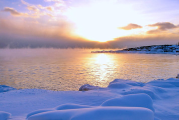 Sunset and cold fog spreads over freezing northern sea - obrazy, fototapety, plakaty
