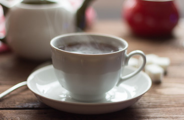 Hot tea in white Cup on wooden table