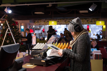 Side view of a girl in headphones listening to vinyl records.