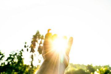 Use hand to touch the sun light in the morning, Pick up the sun, Close the sun in your hand, Yellow light with cold air, Flare light from sunrise, holding sun rays, Symbols of hope, pray for god