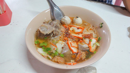 bowl of spicy tom yum noodle soup with pork in Thai style