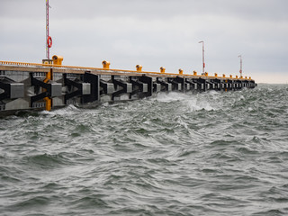 Waves lapping against pier on a windy day