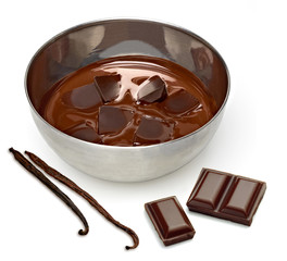 Melting chocolate in bowl with vanilla beans isolated on white background