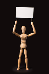 Wooden puppet with a poster or banner in their hands on a black background