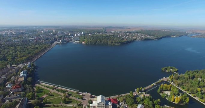 Aerial shooting of city and lake from the quadrocopter. City and lake from the bird's-eye view.