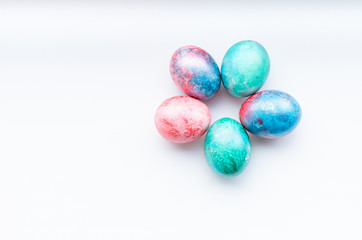 Flat lay of colourful bright easter eggs on a white background.