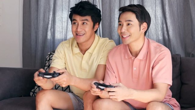 Gay couple playing game together with happy emotion. People with gay, homosexual, lifestyle and relationship concept.