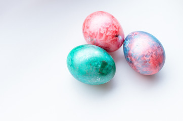 Top view of three colourful easter eggs on a white background.