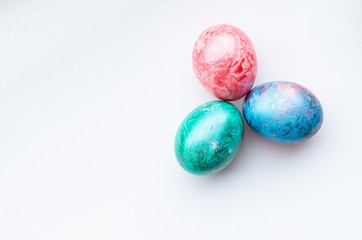 Top view of three colourful easter eggs on a white background.