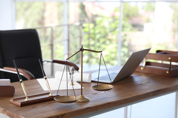 Scales of justice and laptop on desk in notary's office