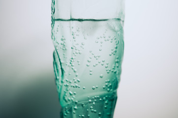 Green blue drinking glass with a cold carbonated mineral water.