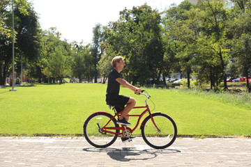 Fototapeta premium Attractive man riding bike outdoors on sunny day