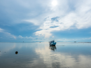 Obraz premium Fisherman boat aground over shallow water