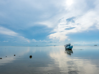 Obraz premium Fisherman boat aground over shallow water