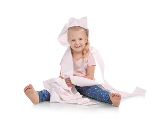 Cute little girl playing with toilet paper on white background