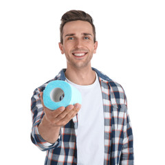 Young man holding toilet paper roll on white background