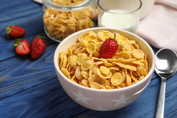 Bowl with healthy cornflakes and strawberry served on wooden table