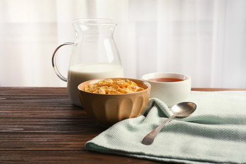 Bowl with healthy cornflakes for breakfast served on wooden table