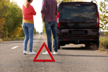Emergency stop sign near people discussing car accident on road. Auto insurance